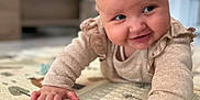 Giulia participe au concours pour gagner de l'argent avec cette photo : baby, infant, crawling, smiling, play_mat, indoor, child, cute, face, hand, clothing, long_sleeve, cheeky, curious, soft_focus, home, floor, pattern, young_child, portrait