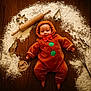 Parker joined the competition — help win amazing prizes! baby, infant, gingerbread_costume, red_bow, flour, wooden_floor, rolling_pin, cookie_cutters, whisk, holiday, christmas, cute, smiling, costume, baking, festive, child, indoors, floor, playful