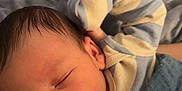 Benjamin is registered to the contest to win money with this photo: baby, newborn, sleeping, pajamas, striped_clothing, blanket, soft_texture, peaceful, infant, cute, face, head, skin, resting, cozy, child, person, indoors, closeup, portrait
