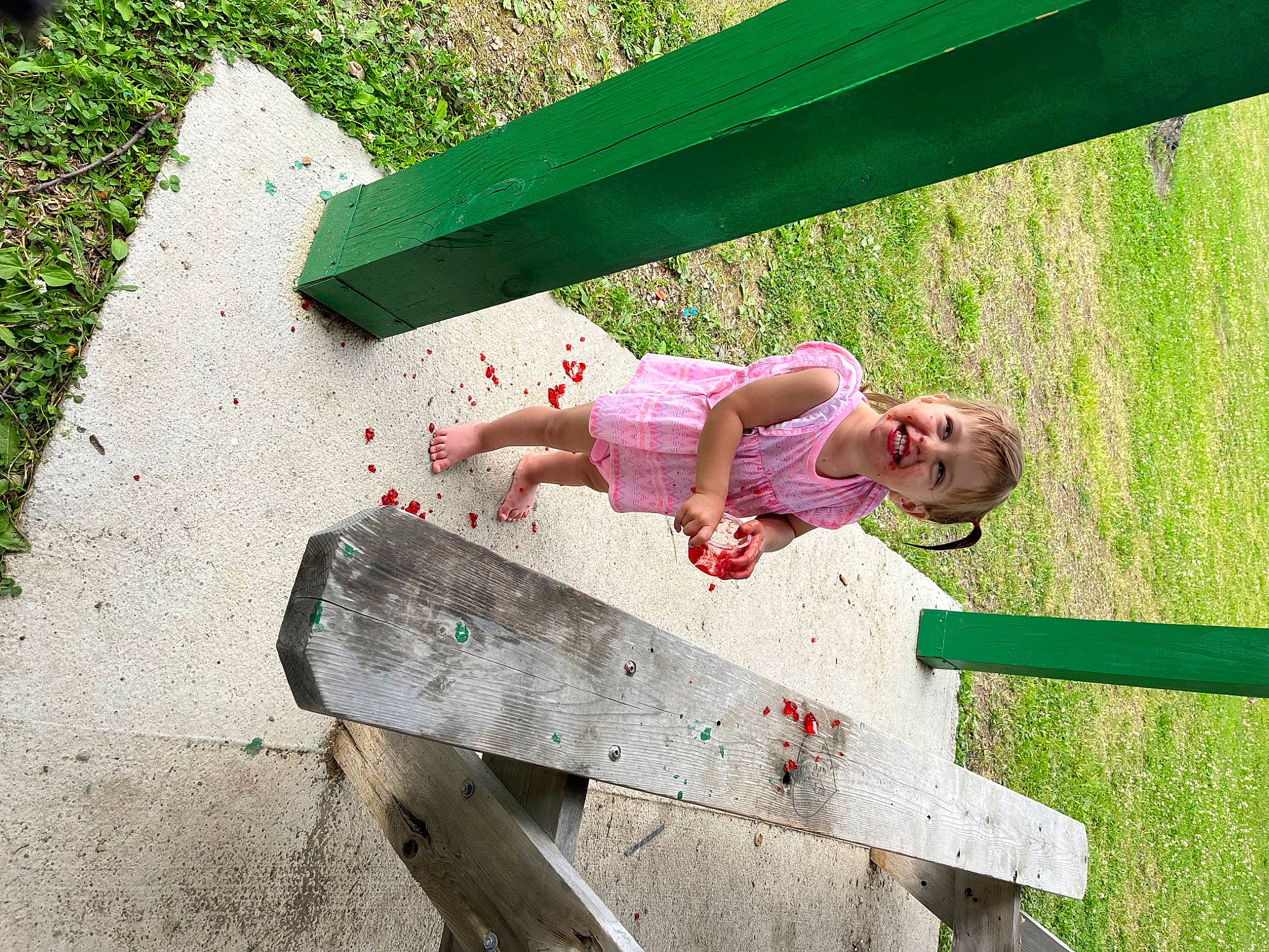 Noelle is registered to the contest to win money with this photo: baby_toddler_clothing, child, city, dress, fun, grass, happy, human_body, joy, leisure, magenta, outdoor_bench, outdoor_furniture, people_in_nature, person, plant, play, recreation, sitting, toddler