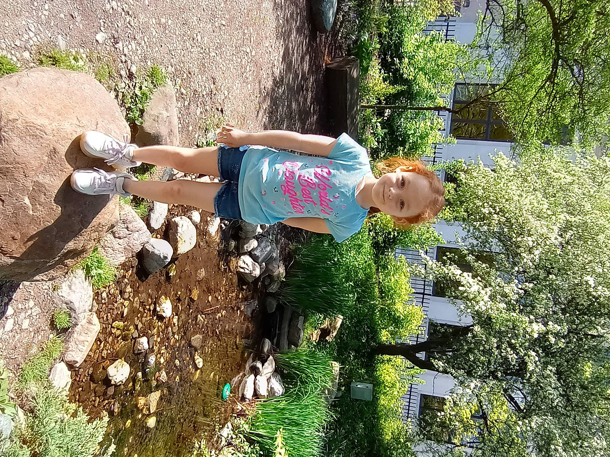 Amberlynn is registered to the contest to win money with this photo: bedrock, fun, garden, grass, groundcover, joy, landscape, leisure, people_in_nature, person, plant, recreation, rock, shorts, shrub, soil, t_shirt, thigh, toddler, tree