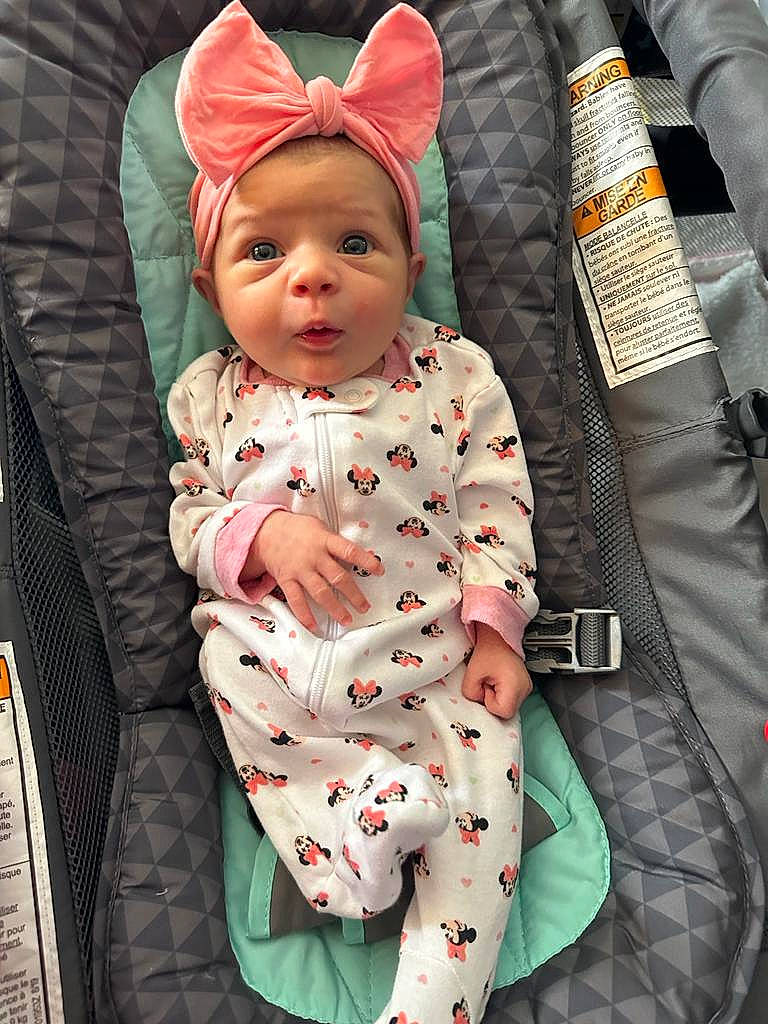 Ariana is registered to the contest to win money with this photo: baby, baby_carriage, baby_products, baby_safety, baby_toddler_clothing, bag, cap, car_seat, carmine, child, comfort, fashion_accessory, linens, outerwear, pattern, person, pink, sitting, sleeve, textile