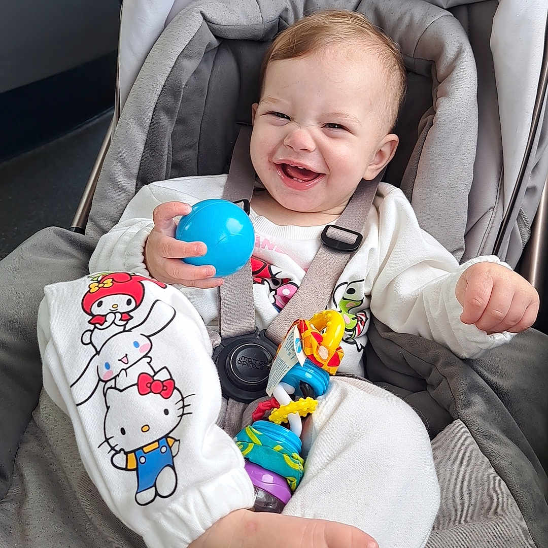 Luna-Grace joined the competition — help win amazing prizes! baby, ball, cartoon_clothing, child, clothing, colorful, comfort, cushion, cute, foot, happy, indoor, infant, person, playful, portrait, seat_belt, smiling, stroller, toy