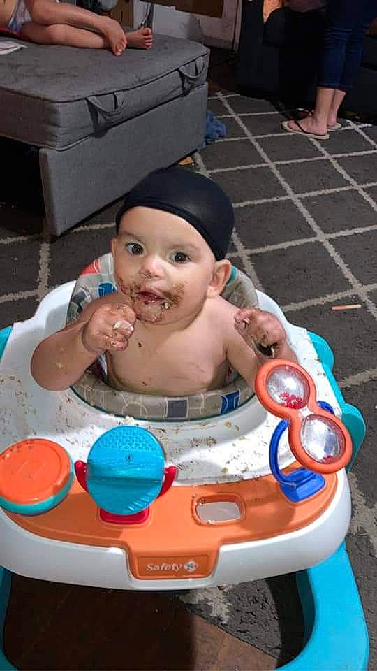 Xaiden is registered to the contest to win money with this photo: baby, baby_products, barechested, bathing, cake, cake_decorating, chest, child, event, fun, happy, headwear, icing, leisure, person, plastic, recreation, shipping_box, sitting, smile