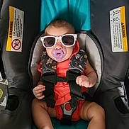 Hadleigh is registered to the contest to win money with this photo: accessories, baby, bodypart, clothing, coat, cushion, face, finger, glasses, glove, hand, head, homedecor, jacket, lifejacket, person, photography, portrait, sunglasses, vest