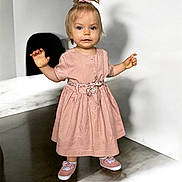 Jade a rejoint le concours — aidez-le/la à gagner de superbes lots ! toddler, child, girl, pink_dress, standing, shoes, pony_tail, bow, marble_floor, shadow, indoor, wall, cute, portrait, person, young_child, happy, clothing, footwear, blonde_hair