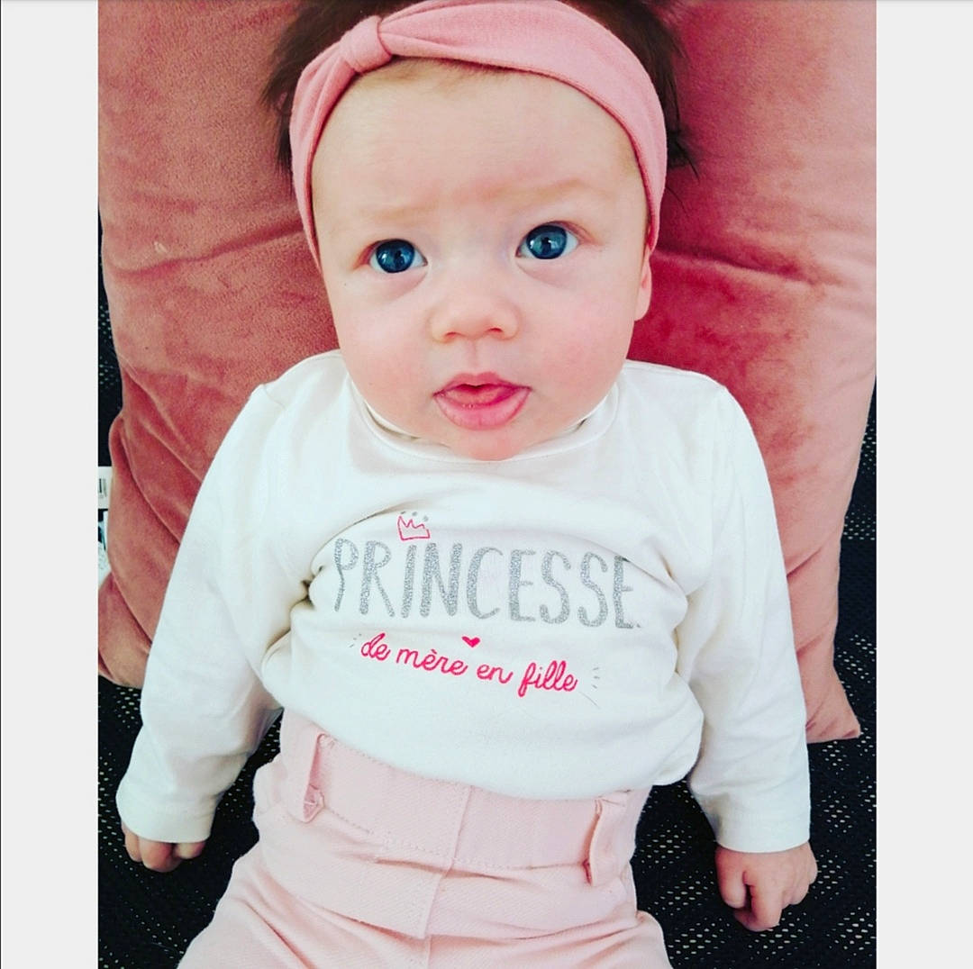 Brooke a rejoint le concours — aidez-le/la à gagner de superbes lots ! baby, baby_products, baby_toddler_clothing, cheek, child, child_model, clothing, cool, ear, hair_accessory, head, headgear, lip, outerwear, person, pink, product, skin, sleeve, t_shirt
