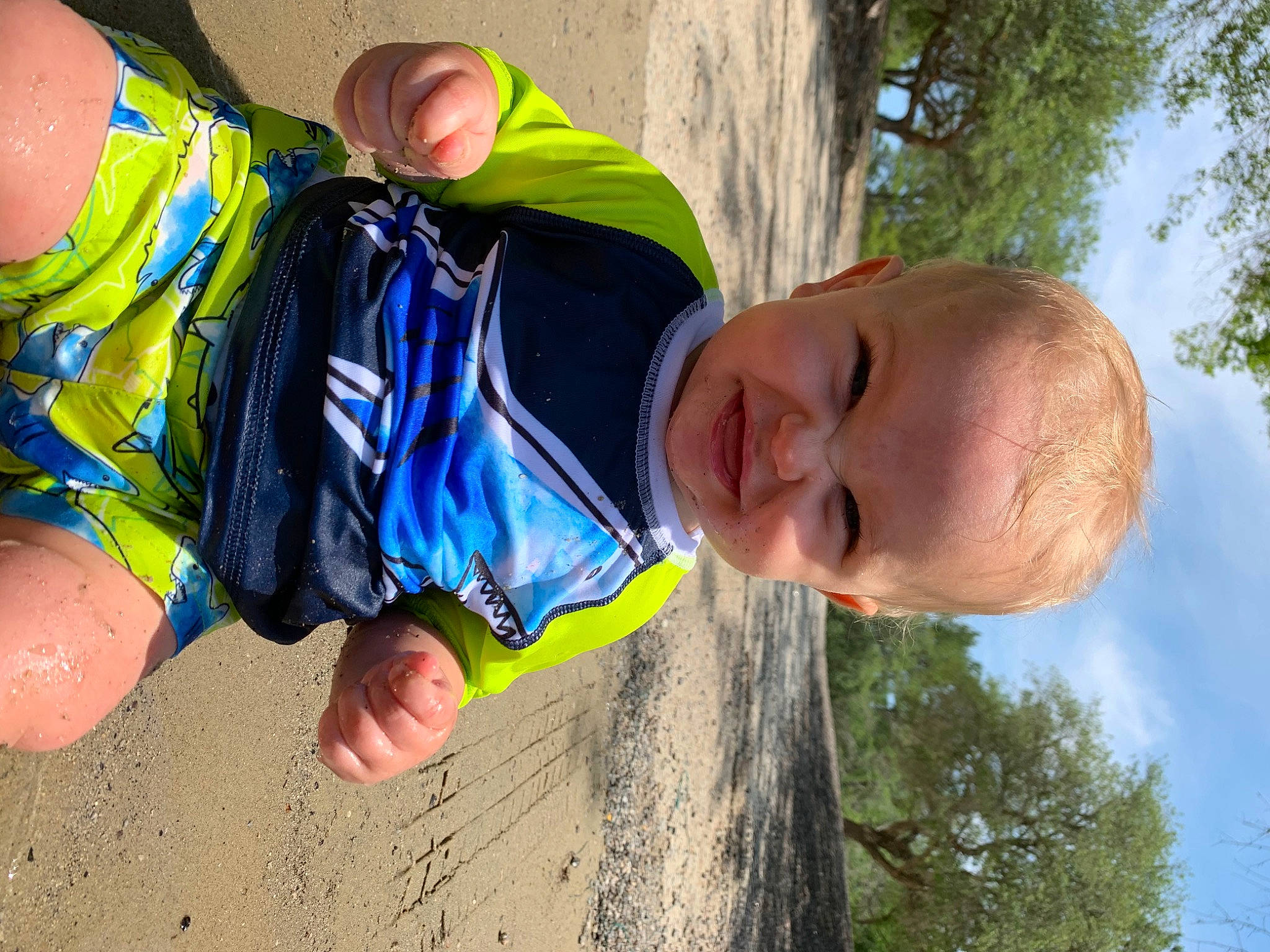 Weston is registered to the contest to win money with this photo: baby, child, electric_blue, facial_expression, fun, gesture, grass, happy, human, joint, leisure, people_in_nature, person, personal_protective_equipment, play, recreation, sky, soil, toddler, tree