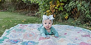 Athena is registered to the contest to win money with this photo: baby, bow, child, clothing, cute, grass, greenery, happy, head, headband, infant, nature, outdoor, patchwork, person, playful, quilt, smiling, toddler, tongue_out