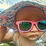 Athena is registered to the contest to win money with this photo: baby, child, sunglasses, hat, floral_hat, outdoor, grass, reflection, face, close_up, person, summer, sunny, cute, infant, fashion, accessory, pink, casual, portrait