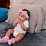 Jimma is registered to the contest to win money with this photo: baby, infant, pink_bow, headband, socks, white_onesie, gray_blanket, pillow, indoor, cute, child, chewing_fingers, sitting, curious, soft_texture, cushion, portrait, young_child, homedecor, cozy