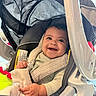 baby, car_seat, smile, happy, infant, blanket, clothing, seatbelt, child, indoor, person, cute, portrait, baby_toy, car_seat_strap, head, cheerful, seat, safety, young_child
