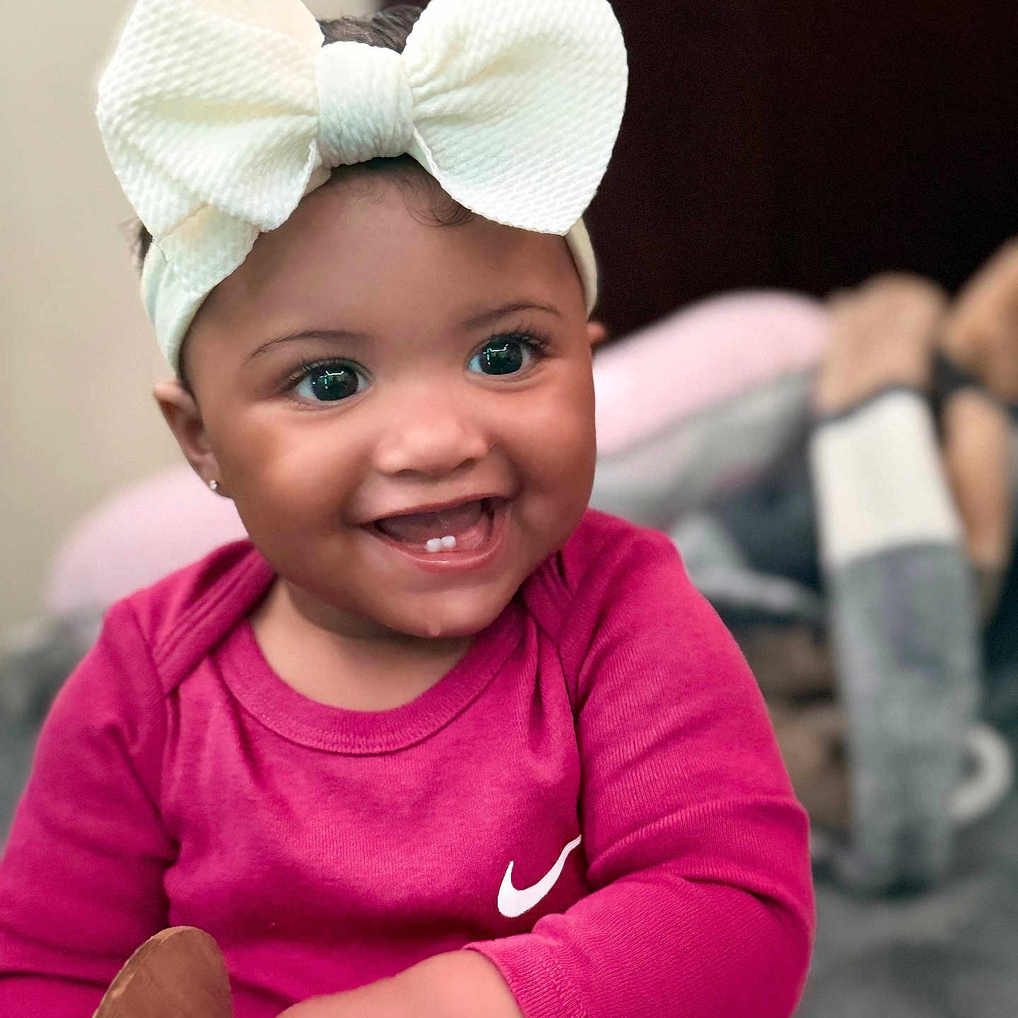 Jimma joined the competition — help win amazing prizes! baby, child, smiling, headband, bow, pink_clothing, face, portrait, happy, indoor, cute, infant, person, holding, wooden_sign, eyes, skin, cheeks, sitting, young