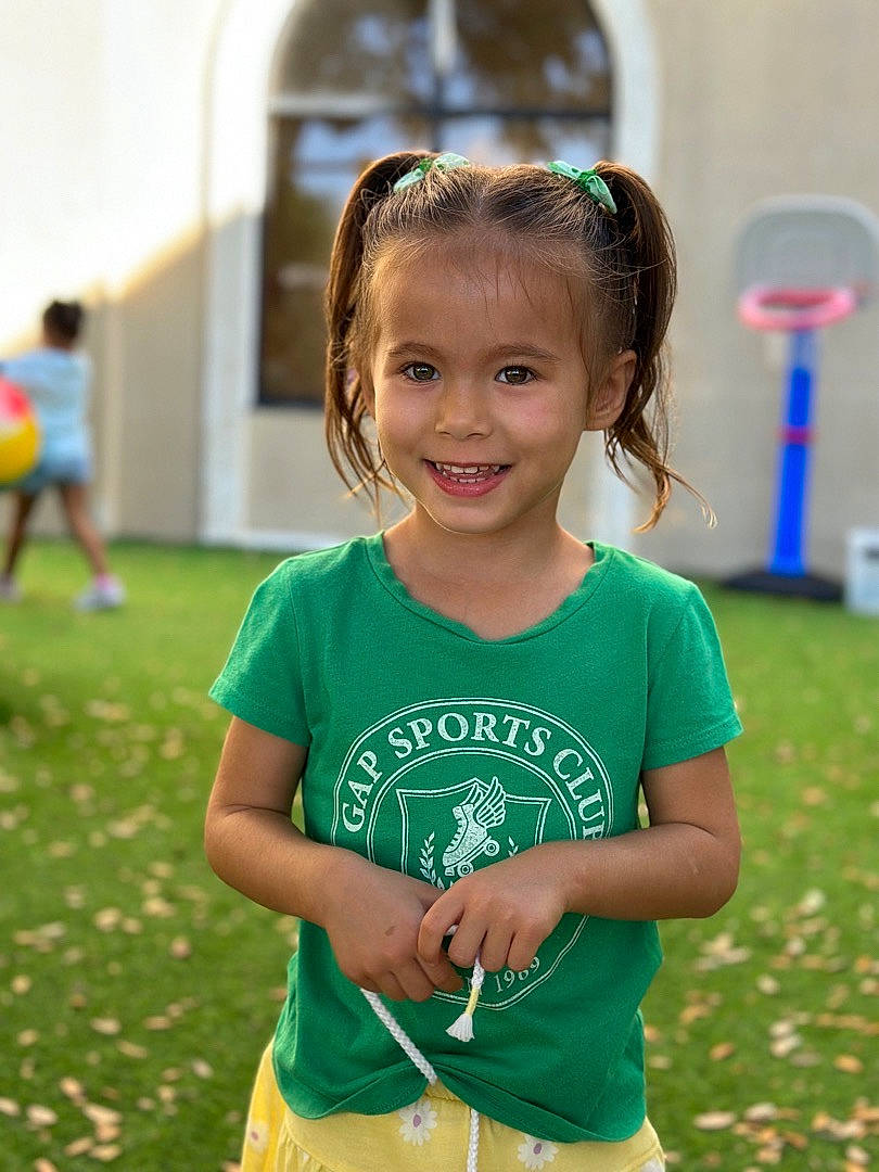 Annabella is registered to the contest to win money with this photo: child, facial_expression, fun, grass, hairstyle, happy, joy, leisure, mammal, people, people_in_nature, person, recreation, shorts, sleeve, smile, spring, standing, summer, t_shirt