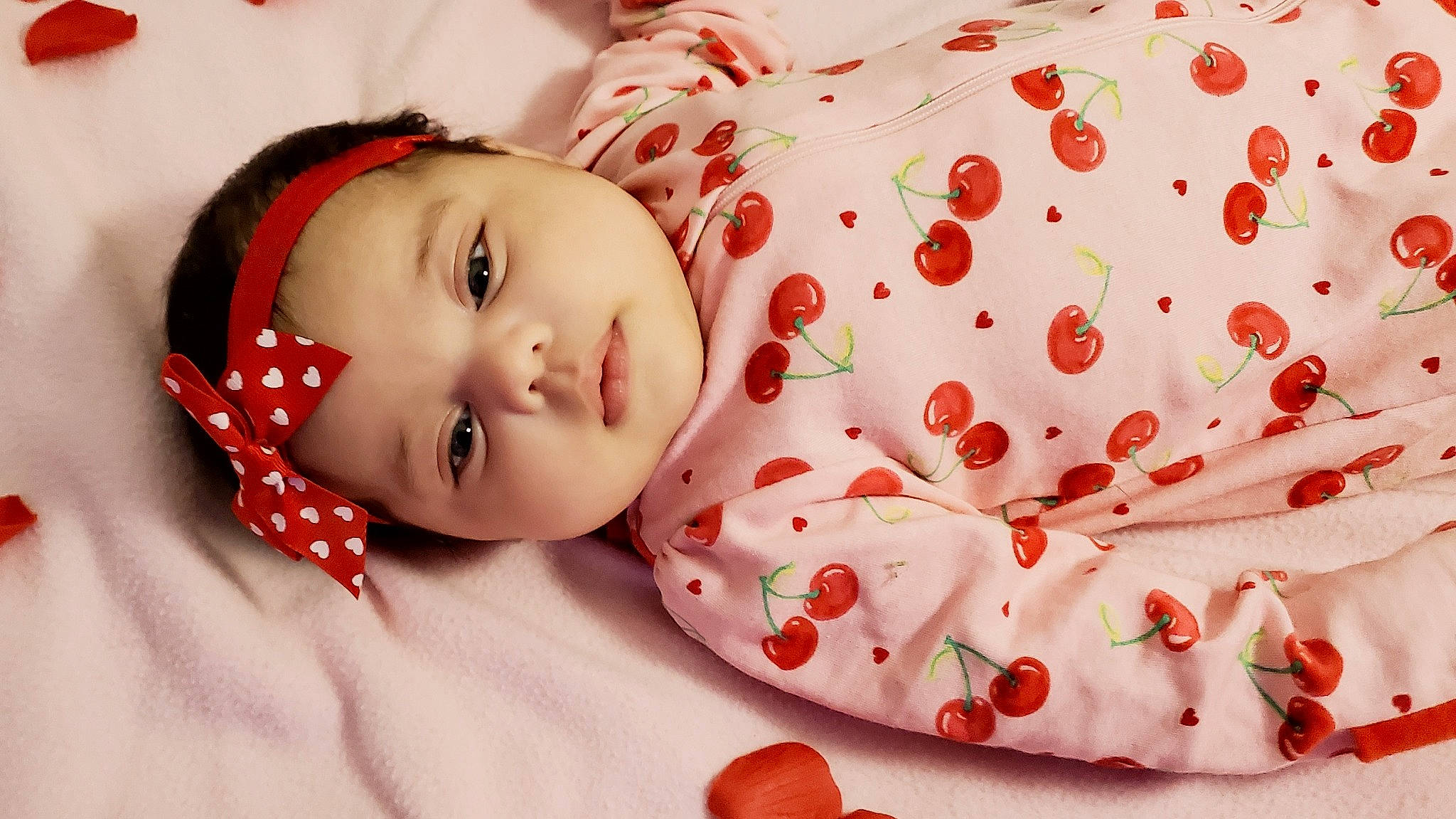 Anahi is registered to the contest to win money with this photo: arm, baby, baby_toddler_clothing, cheek, comfort, dress, eyelash, face, happy, head, headwear, human_body, lip, mammal, nose, pattern, person, pink, skin, sleeve