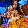 Kimberly is registered to the contest to win money with this photo: baby, child, woman, holding, dress, headband, bow, table, wood, restaurant, indoor, portrait, person, smile, happy, people, hair, skin, face, clothing