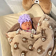 Kimberly is registered to the contest to win money with this photo: baby, blanket, bear_pattern, headband, sleeping, pillow, face, infant, cozy, soft_toys, bed, cute, child, indoors, resting, comfort, warm, newborn, portrait, sleep