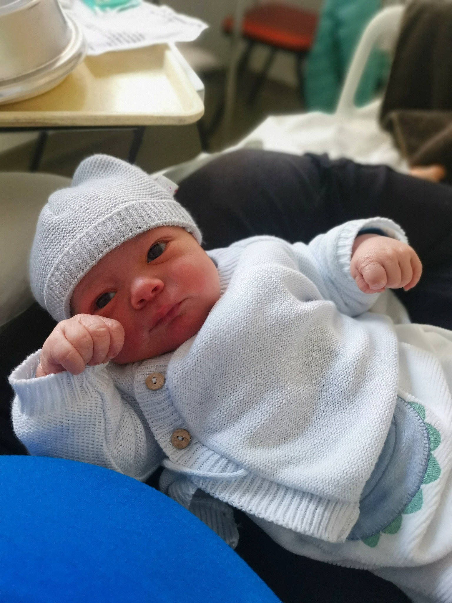 Justin a rejoint le concours — aidez-le/la à gagner de superbes lots ! baby, baby_products, baby_toddler_clothing, cap, cheek, child, comfort, fedora, hat, headwear, mammal, mouth, person, room, saucer, serveware, sitting, skin, sun_hat, tableware