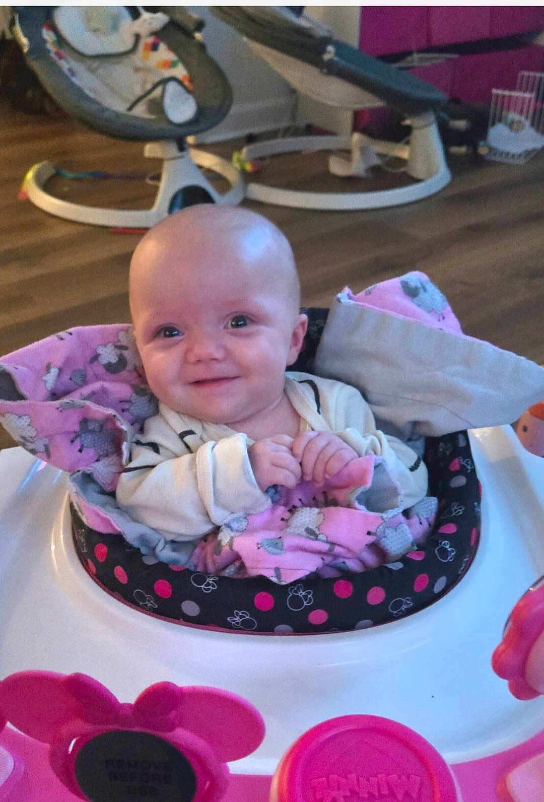 Zoey joined the competition — help win amazing prizes! baby, smiling, infant, blanket, pink, baby_walker, polka_dot, indoor, floor, wooden_floor, toy, child, cute, cozy, person, happy, clothing, furniture, seat, home