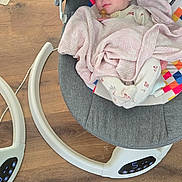 Zoey joined the competition — help win amazing prizes! baby, blanket, pacifier, baby_rocker, floor, wood_floor, infant, child, face, person, clothing, footwear, soft_toy, comfort, indoor, relaxation, seat, modern, cute, gaze