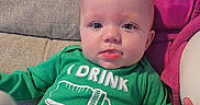 Chloe joined the competition — help win amazing prizes! baby, blanket, bottle_graphic, child, clothing, couch, cute, expression, eyes, face, green_shirt, homedecor, indoors, infant, onesie, pink_blanket, portrait, sitting, sofa, tongue