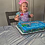 birthday, cake, celebration, chair, child, costume, crown, dessert, food, happy, icing, indoor, mermaid, party_banner, plastic_tablecloth, portrait, smile, sprinkles, table, toddler