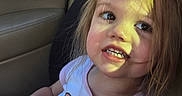 Alaina is registered to the contest to win money with this photo: backseat, candid, car_interior, child, cute, hand, long_hair, pink_clothing, portrait, safety, seat, seatbelt, shirt, smile, sunlight, teeth, toddler, toy, window, young_child