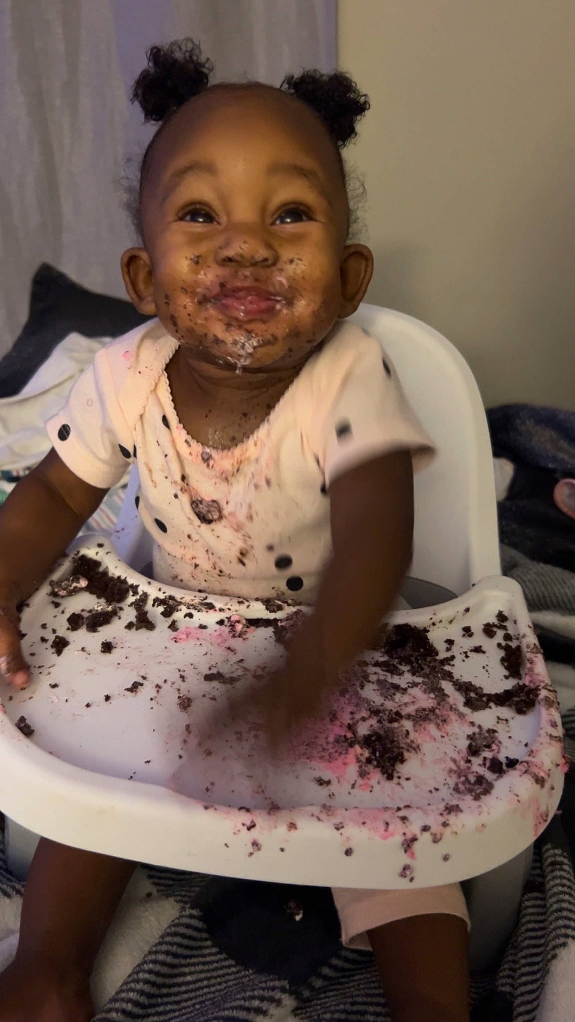 Avyanna is registered to the contest to win money with this photo: baby_toddler_clothing, black, chair, cheek, eye, face, finger, hair, hand, happy, head, human_body, iris, lip, organ, person, pink, skin, smile, toddler