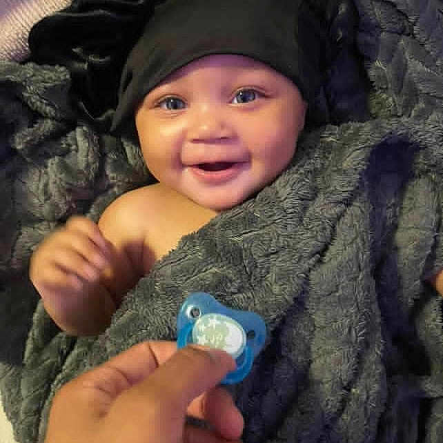 Ziyah joined the competition — help win amazing prizes! baby, black_bonnet, blanket, blue_eyes, child, comfort, cozy, cute, face, hand, happy, indoor, infant, joy, pacifier, portrait, skin, smiling, soft_texture, wrapped