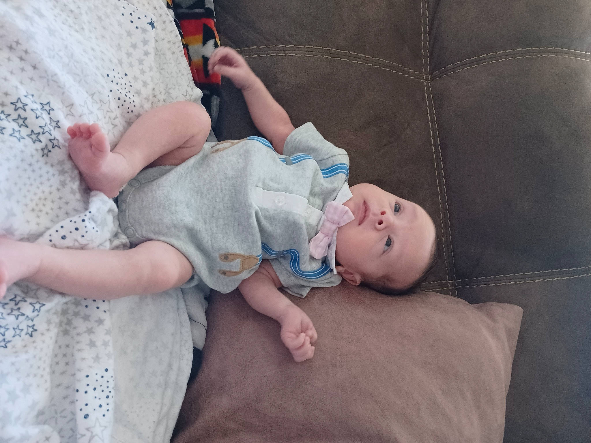 Zakaria is registered to the contest to win money with this photo: baby, baby_toddler_clothing, child, comfort, couch, finger, foot, grass, hand, hat, human_body, human_leg, linens, pattern, person, room, sitting, skin, sock, toddler