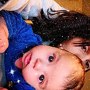 Aimé a rejoint le concours — aidez-le/la à gagner de superbes lots ! baby, child, person, face, eyes, hair, blue_clothing, long_hair, indoor, portrait, closeup, sparkle_effect, hand, skin, cute, infant, holding, warm_lighting, expression, background