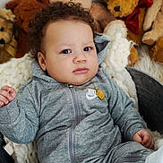 Myles is registered to the contest to win money with this photo: baby, child, teddy_bear, plush_toy, gray_tracksuit, nike_logo, metal_tub, blanket, curly_hair, white_shoes, indoor, portrait, cute, infant, soft_texture, cozy, expression, person, sitting, toy