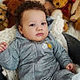 baby, child, teddy_bear, plush_toy, gray_tracksuit, nike_logo, metal_tub, blanket, curly_hair, white_shoes, indoor, portrait, cute, infant, soft_texture, cozy, expression, person, sitting, toy