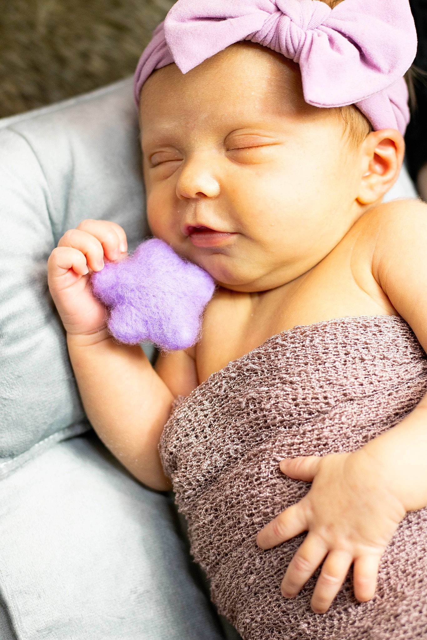 Delilah is registered to the contest to win money with this photo: arm, baby, baby_toddler_clothing, cheek, chin, comfort, ear, facial_expression, finger, gesture, hand, happy, lip, mouth, neck, nose, person, pink, purple, skin
