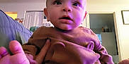 Miles joined the competition — help win amazing prizes! baby, infant, child, indoor, home, looking_up, purple_light, clothing, cute, sitting, feet, face, expression, person, young, casual, cozy, living_room, blanket, relaxed