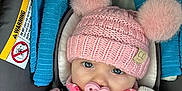 Lauren is registered to the contest to win money with this photo: baby, infant, pacifier, hat, knitted_hat, pom_poms, plush_toy, car_seat, fleece_jacket, colorful_clothing, child, cute, face, hand, blue_strap, warning_label, indoor, portrait, closeup, warm_clothing