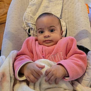Leyna participe au concours pour gagner de l'argent avec cette photo : baby, infant, pink_jacket, blanket, baby_seat, indoor, child, cute, portrait, expression, cozy, hands, clothing, face, young, soft, comfort, seated, person, furniture