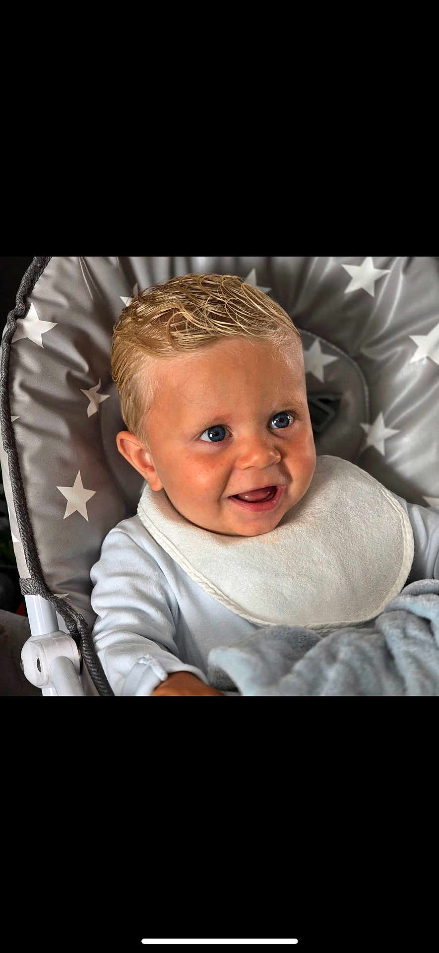 Beau-Harley is registered to the contest to win money with this photo: baby, child, infant, smiling, blue_eyes, blonde_hair, bib, blanket, baby_seat, star_pattern, clothing, cute, face, happy, indoors, person, portrait, seat, soft, young
