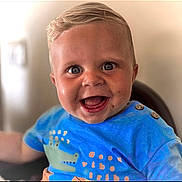 Beau-Harley is registered to the contest to win money with this photo: toddler, child, smiling, blue_shirt, crocodile_print, happy, face, portrait, short_hair, indoor, baby, cute, cheerful, person, young_child, closeup, sitting, expression, playful, bright_eyes