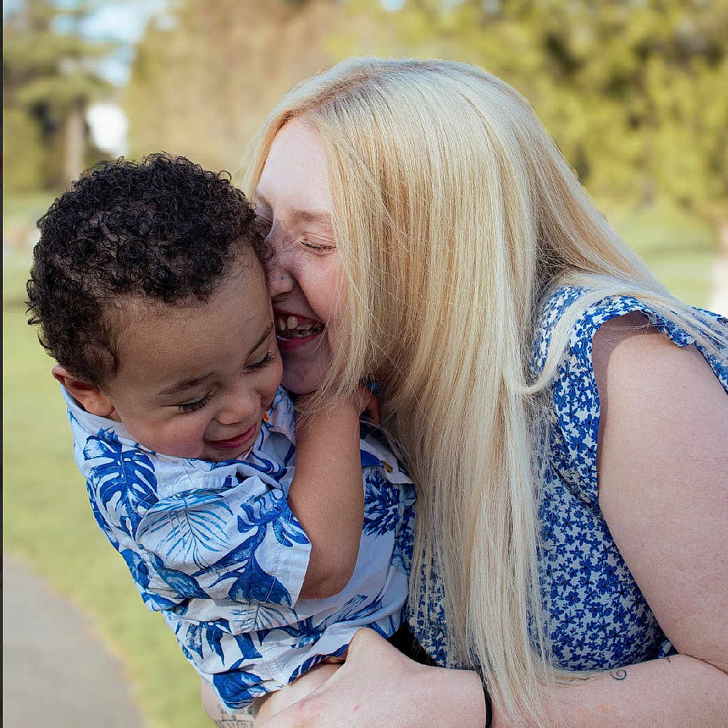 Caiden is registered to the contest to win money with this photo: adult, baby, ball, clothing, face, female, happy, head, hugging, jeans, laughing, pants, people, person, photography, portrait, rugby, rugbyball, sport, woman