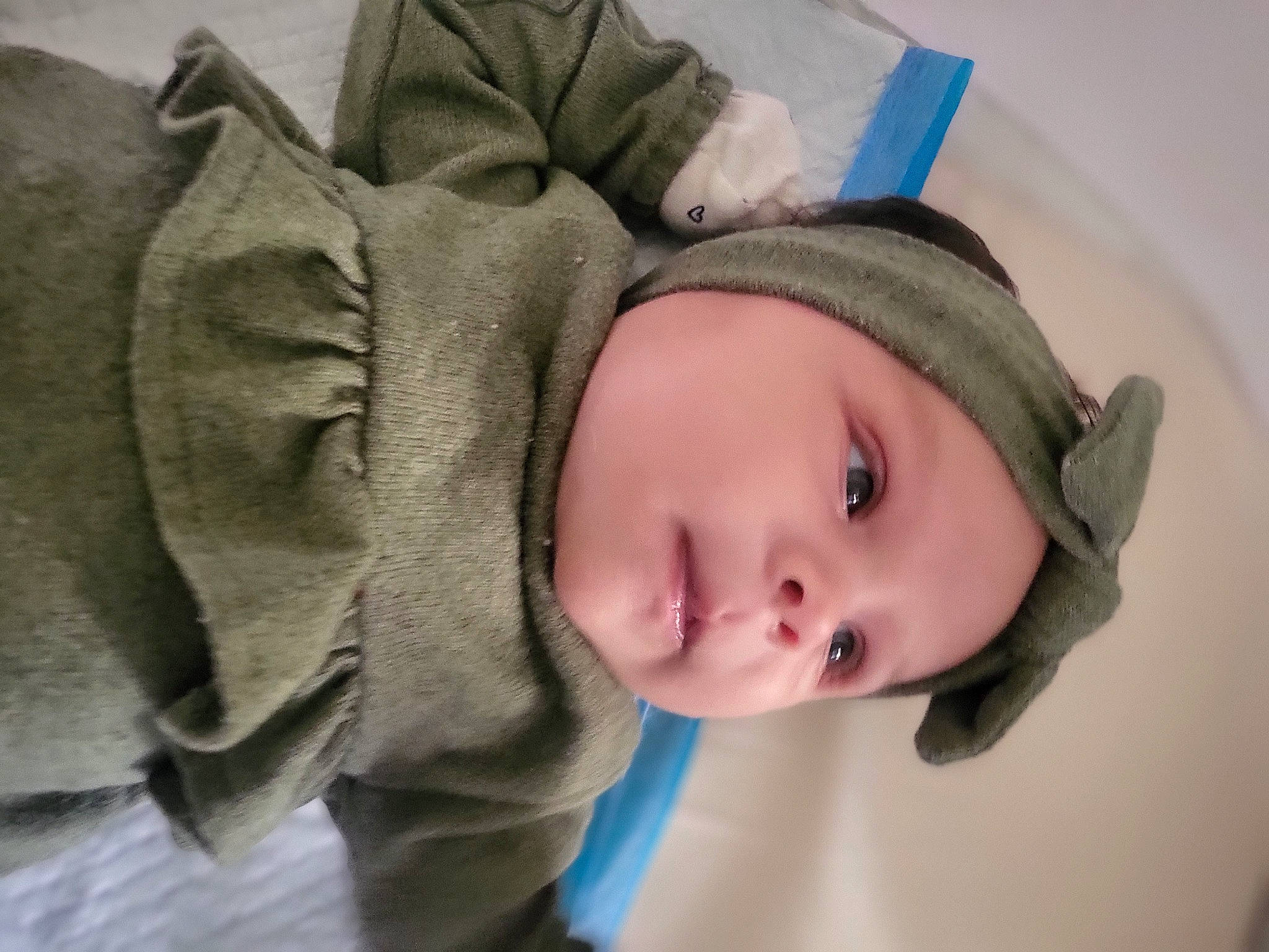 Logan is registered to the contest to win money with this photo: baby, cap, cheek, child, chin, comfort, eye, eyelash, face, facial_expression, head, headgear, headwear, linens, mouth, nose, outerwear, person, skin, textile