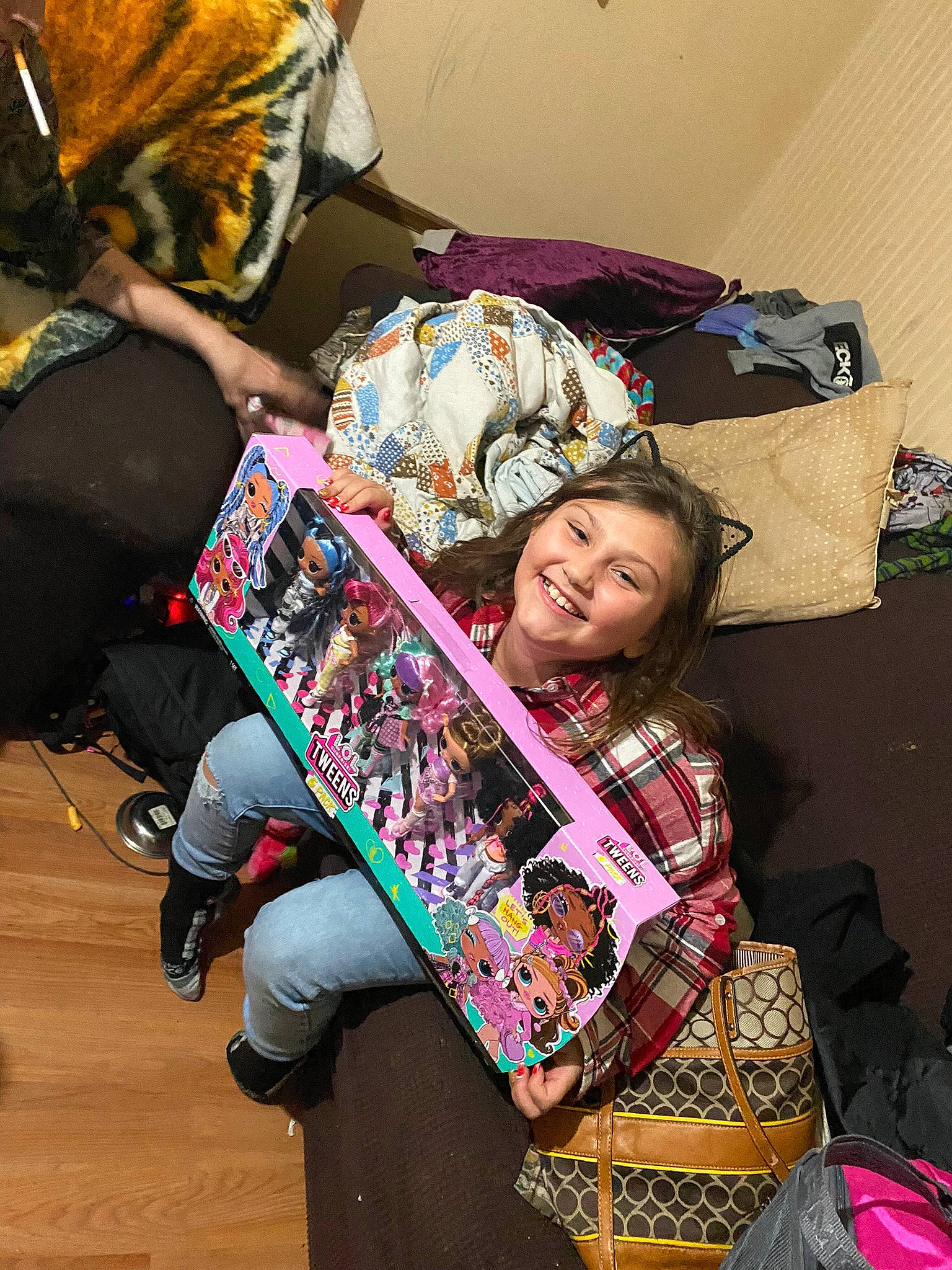 Colombiana is registered to the contest to win money with this photo: bag, child, comfort, event, fashion_accessory, fun, fur, hairstyle, happy, joy, leisure, linens, luggage_and_bags, magenta, pattern, person, room, shoe, sitting, smile