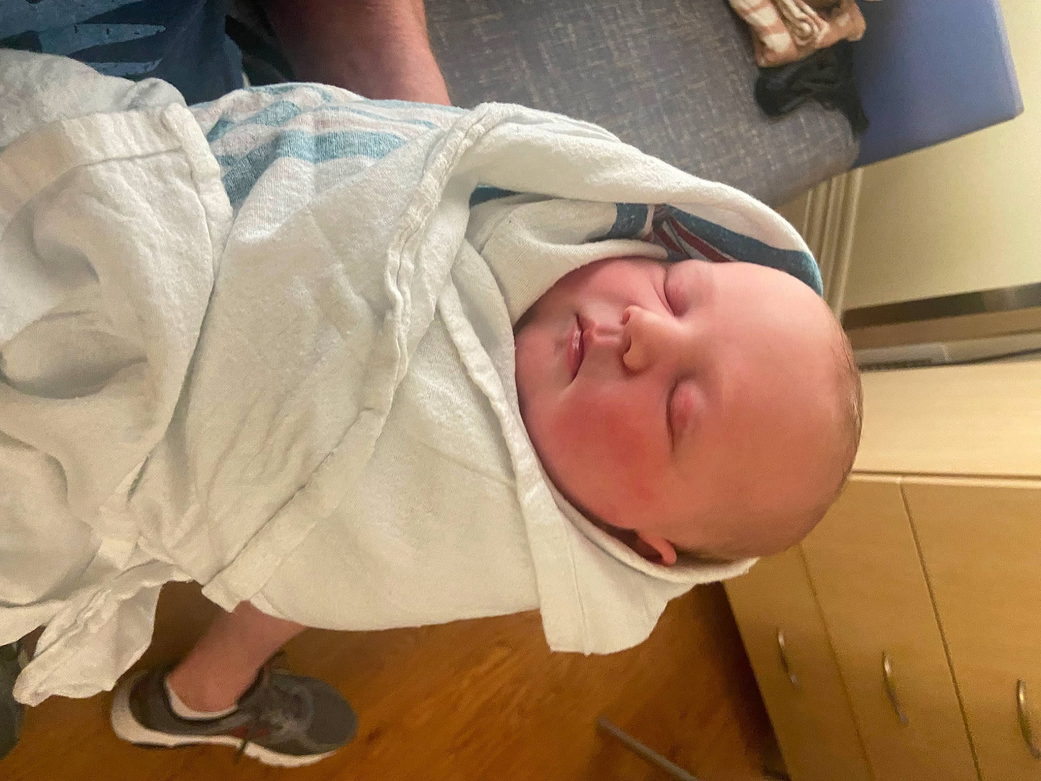 Ezra is registered to the contest to win money with this photo: baby, baby_products, baby_safety, baby_toddler_clothing, cheek, child, comfort, floor, flooring, foot, glasses, hardwood, head, linens, nose, person, skin, sleeve, smile, toddler