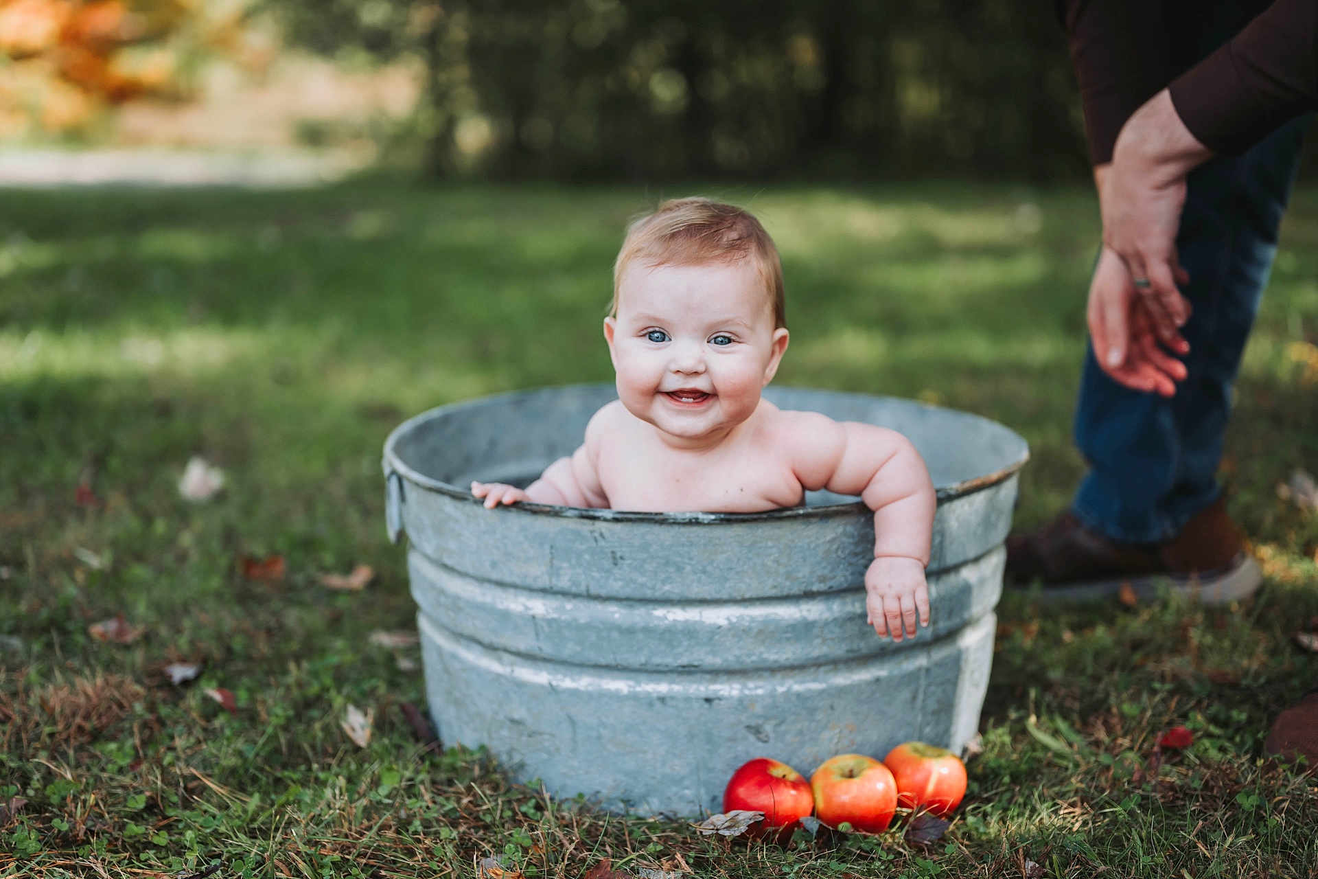 Iris joined the competition — help win amazing prizes! baby, child, metal_tub, outdoor, grass, apples, smiling, happy, blue_eyes, bare_chest, person, nature, adult_hand, fall, rustic, cute, infant, portrait, greenery, playful