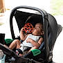Connor participe au concours pour gagner de l'argent avec cette photo : baby, sleeping, stroller, toy, orange_ball, child, infant, car_seat, black, peaceful, relaxing, daylight, outdoor, clothing, cute, portrait, baby_boy, hand, foot, comfort
