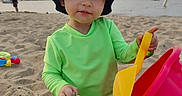 Luca joined the competition — help win amazing prizes! beach, boat, bucket, child, green_clothing, hat, outdoor, person, play, recreation, sand, sand_toys, sea, shovel, summer, sunlight, toddler, toy, vacation, water