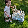 toddler, child, toy, wooden_toy, grass, outdoor, play, walking, sunlight, shoes, shorts, summer, nature, greenery, cute, happy, baby, person, playtime, daytime