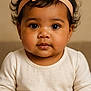 Lïyana a rejoint le concours — aidez-le/la à gagner de superbes lots ! baby, infant, child, headband, bow, curly_hair, brown_eyes, chubby_cheeks, cream_top, portrait, close_up, cute, adorable, innocent, soft_lighting, neutral_background, sitting, young_child, face, person