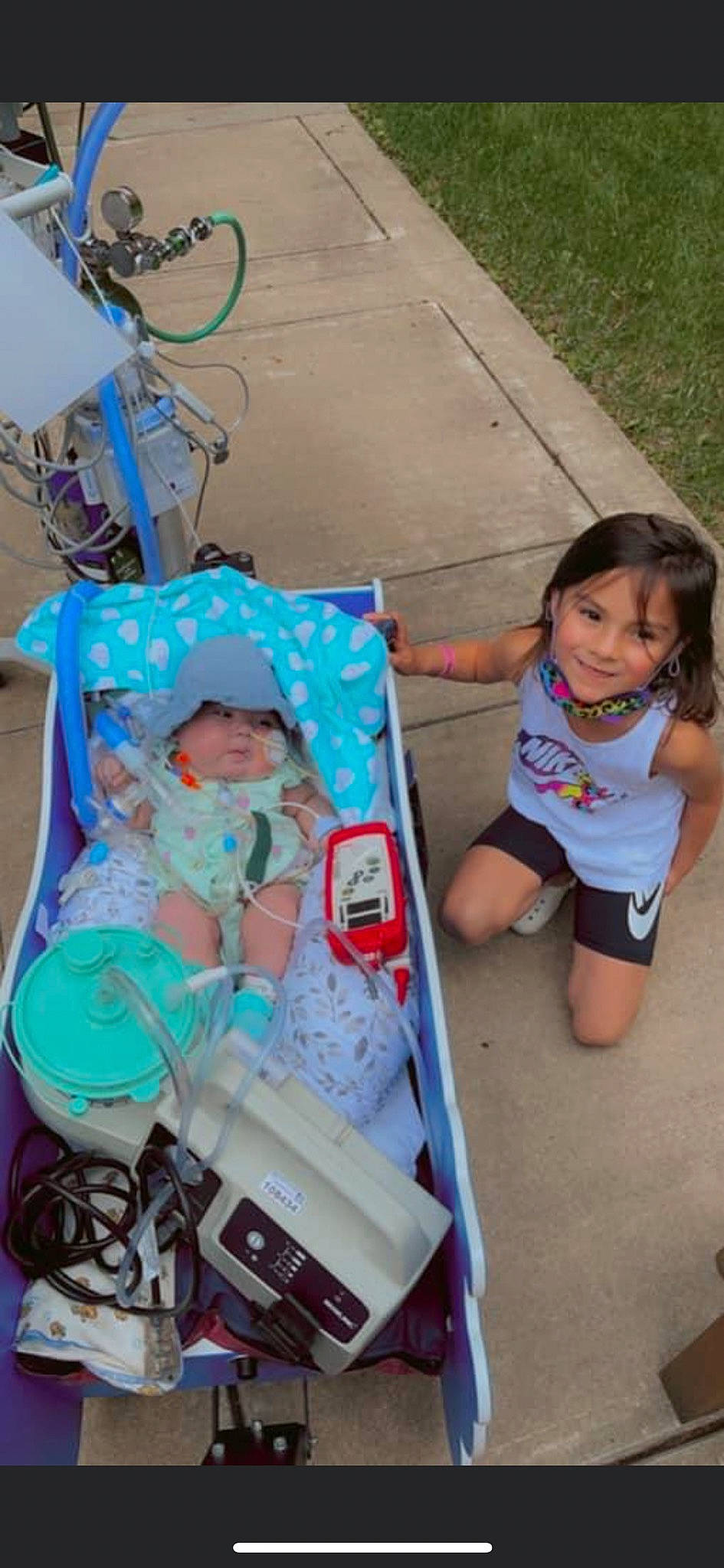 Haizlee is registered to the contest to win money with this photo: baby_carriage, baby_products, bicycle_tire, bicycle_wheel, child, event, fun, grass, headwear, joy, leisure, person, photograph, pink, product, shorts, sitting, smile, snapshot, summer