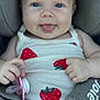 baby, infant, car_seat, pacifier, strawberry_print, white_tank_top, cute, smiling, tongue_out, child, seatbelt, safety_harness, closeup, portrait, skin, hands, blue_eyes, hair, clothing, sitting